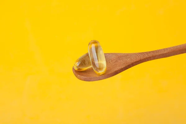 Tobolka Vitamínovou Pilulkou Omega Dřevěné Lžičce Žlutém Pozadí Zdravá Strava — Stock fotografie
