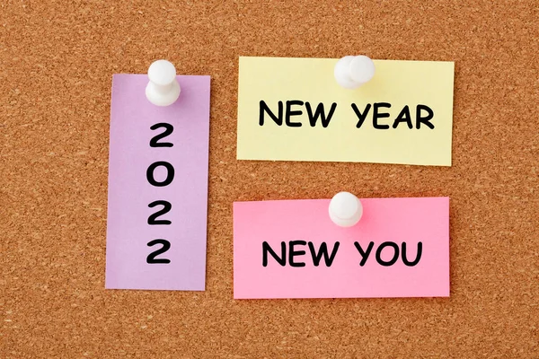 New year, new you text on colorful notes pinned on cork board.