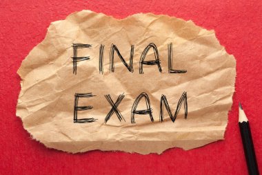 Final exam text on wrinkled lined paper with pencil. Motivation concept.