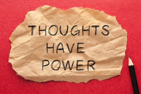 Thoughts have power text on wrinkled lined paper with pencil.