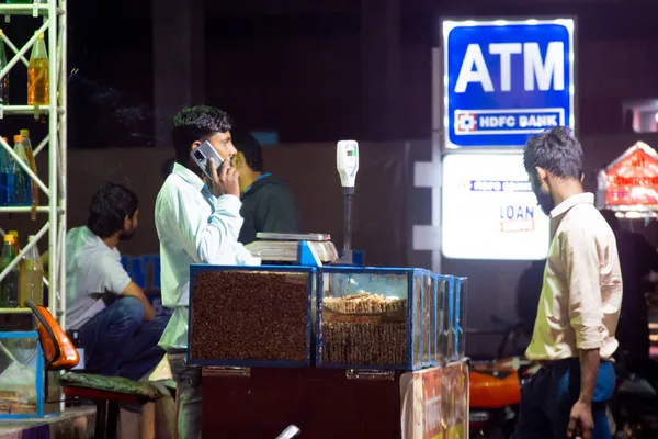 Γλυκό και φυστίκι πωλητής στέκεται στην άκρη του δρόμου μιλώντας στο τηλέφωνο, ενώ περιμένουν για τους πελάτες ενάντια σε ένα σημάδι της τράπεζας HDFC δείχνουν ένταξη και τα κέρδη κατά τη διάρκεια του φεστιβάλ hindu της diwali — Φωτογραφία Αρχείου