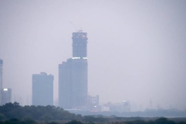 Delhi 'nin en yüksek binasını gösteren sisin içinden çekilen süperteknoloji süpernova çok katlı bir bina hala inşa halinde ve evleri, ofisleri ve gayrimenkulleri barındıracak.