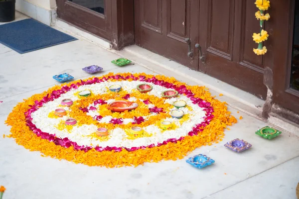 Rangoli pookalam minta virágszirmok kézzel készített diya lámpák körül a földön a vallási ünnepségek, mint a diwali, karácsony és újév — Stock Fotó