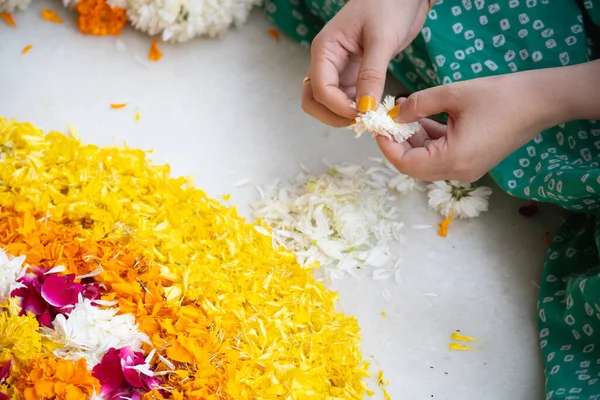 Fiatal indiai nők kezét könnyező jázmin virágok, így a szirmok lehet használni a dekoráció, rituális, rangolis a fesztivál Diwali, újév vagy egy esküvő a hindu hagyomány — Stock Fotó