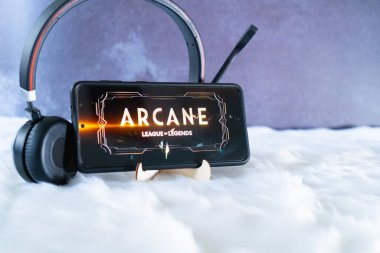 cep telefonu kürklü kar yüzeyine yerleştirilmiş kulaklıklarla beklemede. Arcane Popüler Netflix Şov 'u izliyorlar.