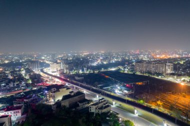 Gökyüzü insansız hava aracı görüntüsü, yüksek metro istasyonunu ve yoğun cadde üzerindeki trafik ve şehir manzarasını gösteriyor. Gurgaon, Jaipur Hindistan 'da
