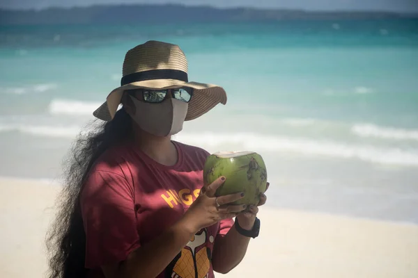 Молода дівчина в солом'яному капелюсі стоїть на пляжі в окулярах і масках через кові19 коронавірусну пандемію і кокос у відпустці в havelock swaraj dswaraj dweep andaman nicobar Island india — стокове фото
