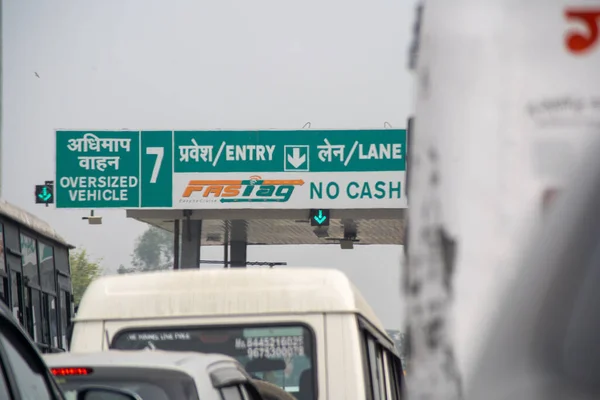 新しいRFIDベースの支払いシステムを示す有料ブースの前で混雑した交通渋滞車インドの国道当局のロゴとともにFASTag NHAI — ストック写真
