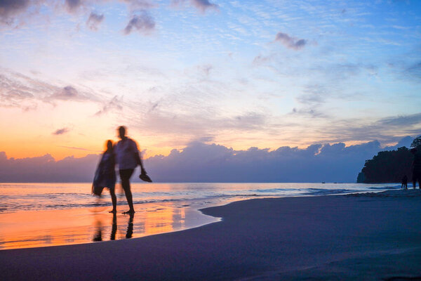 силуэт размыл людей на пляже с красивым оранжевым, синим облачным закатом на пляже Апатар в андаманском городе Индия
