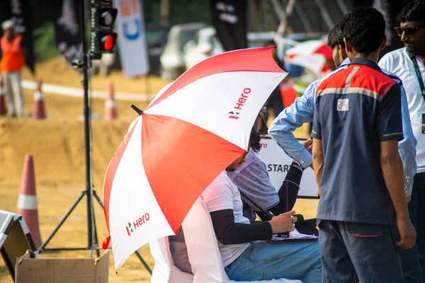 Gurgaon, Delhi, Hindistan - 2022 dolaylarında: Bir off-road pistinde oturan adam, bir şemsiyeye yazılmış kahramanla her yerde kalabalık