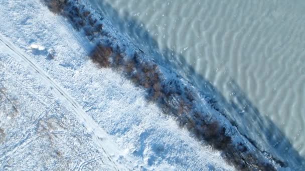 Filmen Vanuit Lucht Een Bevroren Rivier Tussen Een Besneeuwde Weide — Stockvideo