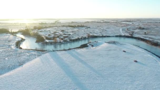 Filmen Vanuit Lucht Een Bevroren Rivier Tussen Een Besneeuwde Weide — Stockvideo