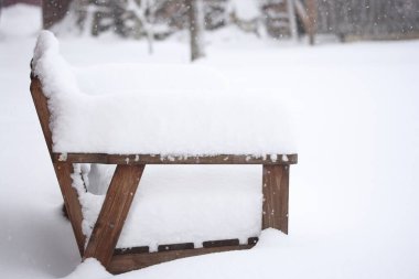 Karla kaplı ahşap bahçe bankı
