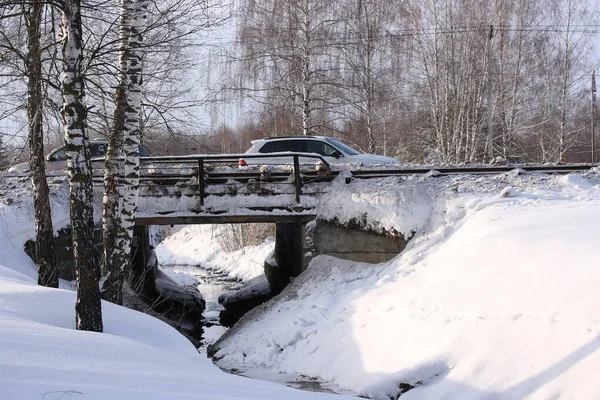 Unfrozen Stream Flowing Bridge Snow Covered Banks — стоковое фото