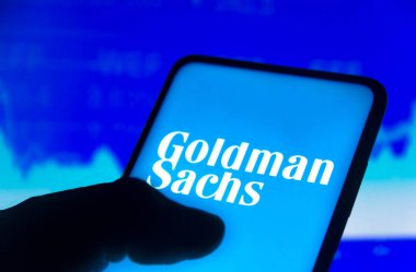 15 Kasım 2021, Brezilya. Bu resimde Goldman Sachs Group logosu bir akıllı telefon ekranında ve arka planda bir borsa grafiğinde gösterildi.