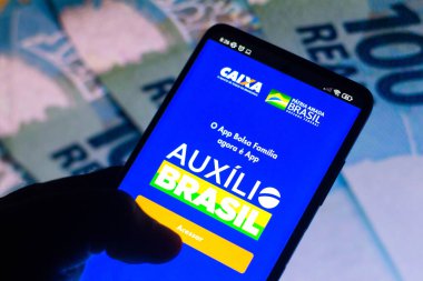 18 Kasım 2021, Brezilya. Bu resimde Auxlio Brasil logosu akıllı telefondan gösteriliyor. Bolsa Famlia 'nın yerine geçen Brezilya hükümetinin sosyal programıdır..