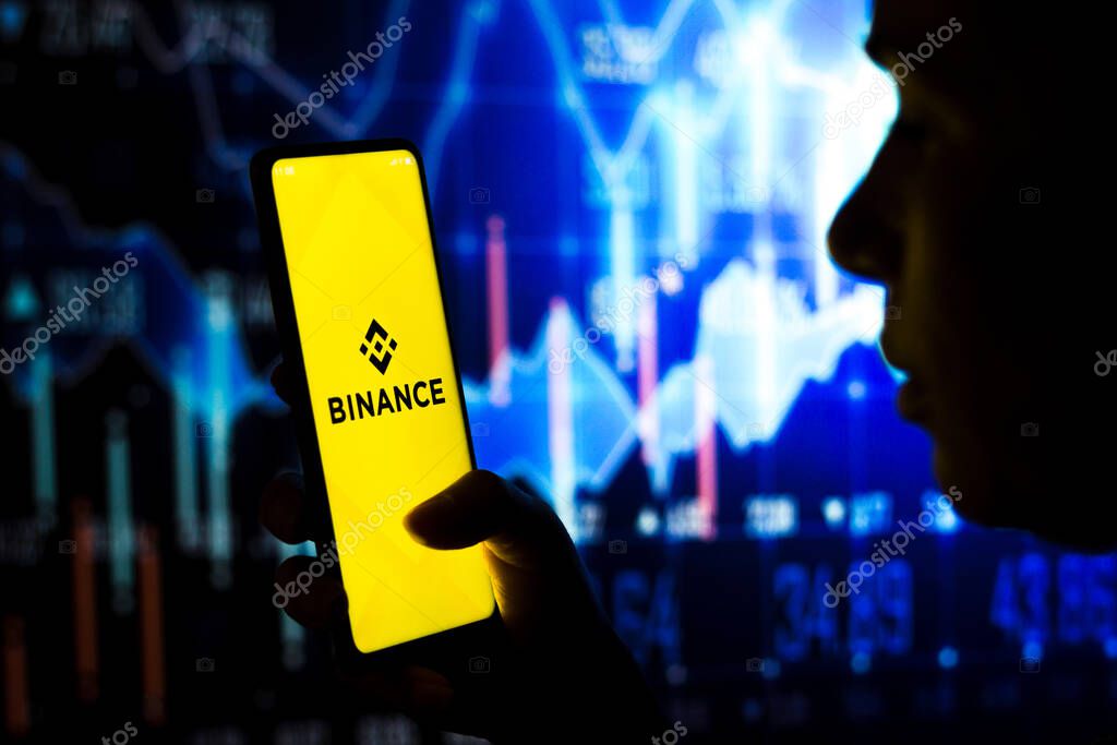 March 19, 2022, Brazil. In this photo illustration, a woman holds a smartphone with the Binance (BNB) logo displayed on the screen