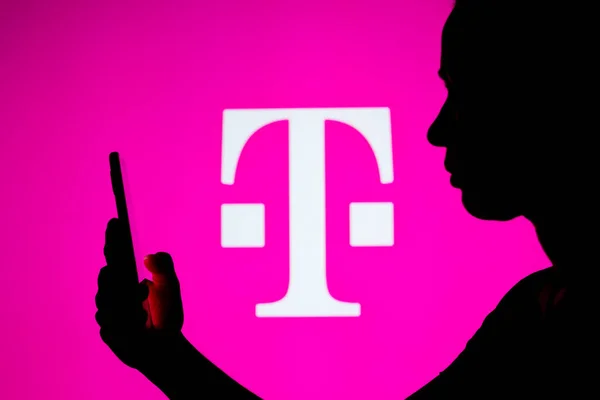 2022年3月22日 在这张照片中 一个女人的轮廓是拿着一个带有T Mobile Deutsche Telekom 标志的智能手机作为背景 — 图库照片