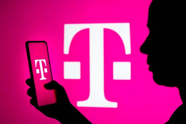 2022年3月22日 在这张照片中 一个女人的轮廓在背后有一个带有T Mobile Deutsche Telekom 标志的智能手机 — 图库照片