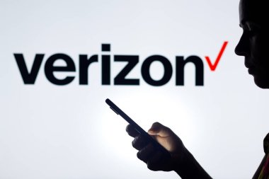 30 Mart 2022, Brezilya. Bu resimde, bir kadının siluetinde arka planda Verizon İletişim logosu olan bir akıllı telefon var.