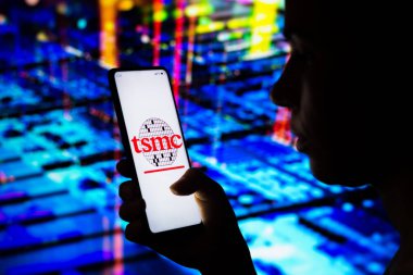 10 Nisan 2022, Brezilya. Bu resimde, bir kadın ekranda gösterilen Tayvan Yarı iletken Üretim Şirketi (TSMC) logosuna sahip bir akıllı telefon tutuyor.