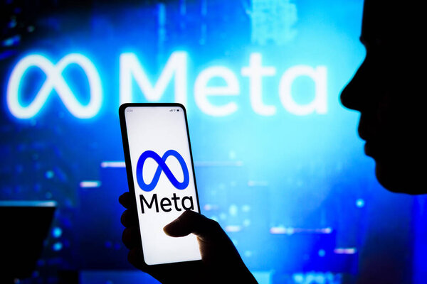 April 10, 2022, Brazil. In this photo illustration, a woman holds a smartphone with the Meta Platforms, Inc. logo displayed on the screen