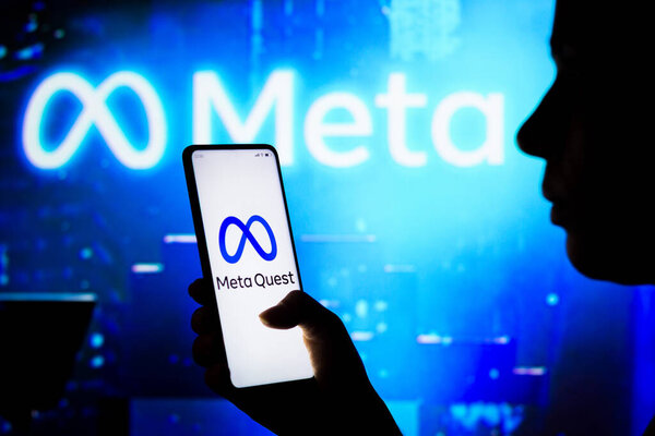 April 10, 2022, Brazil. In this photo illustration, a woman holds a smartphone with the Meta Quest logo displayed on the screen