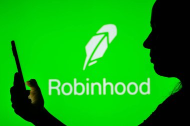 12 Nisan 2022, Brezilya. Bu resimde, arka planda Robinhood Market logosu olan bir kadın silueti var.