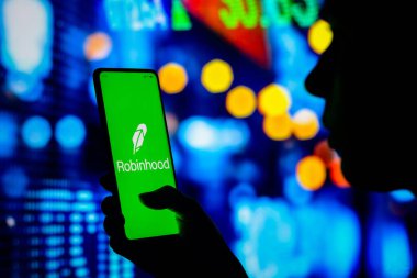 12 Nisan 2022, Brezilya. Bu resimde, bir kadın ekranda Robinhood Market logosunun sergilendiği bir akıllı telefon tutuyor.
