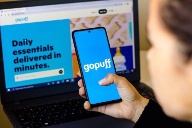 18 Nisan 2022, Brezilya. Bu resimde, bir kadın arka planda Gopuff web sitesinin görüntülendiği ekranda Gopuff logosunun gösterildiği bir akıllı telefon tutuyor.