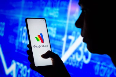 21 Nisan 2022, Brezilya. Bu resimde, bir kadın ekranında Google Cüzdan logosu olan bir akıllı telefon tutuyor.