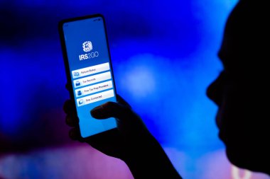 21 Nisan 2022, Brezilya. Bu resimde, bir kadın ekranda IRS2Go (İç Gelir Servisi) logosu sergilenen bir akıllı telefon tutmaktadır.