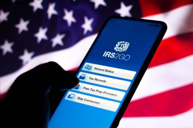 21 Nisan 2022, Brezilya. Bu resimde, bir kadın ekranda IRS2Go (İç Gelir Servisi) logosu sergilenen bir akıllı telefon tutmaktadır.