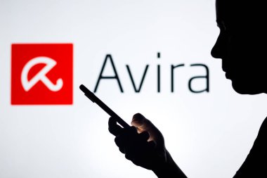 27 Nisan 2022, Brezilya. Bu resimde Avira Antivirus logosu, elinde cep telefonu olan siluetli bir kadının arka planında görülüyor.