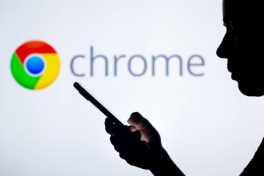 27 Nisan 2022, Brezilya. Bu resimde, Google Chrome logosu cep telefonu tutan siluetli bir kadının arka planında görülüyor.