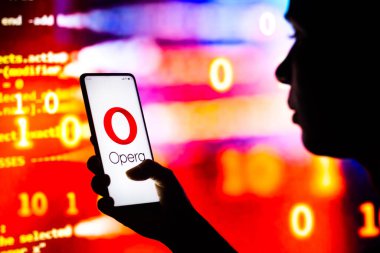27 Nisan 2022, Brezilya. Bu resimde siluetli bir kadın ekranında Opera logosu olan bir akıllı telefon tutuyor.