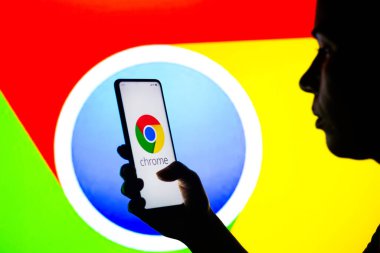 27 Nisan 2022, Brezilya. Bu resimde siluetli bir kadın ekranda Google Chrome logosu olan bir akıllı telefon tutuyor.