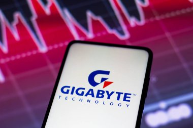 May 4, 2022, Brazil. In this photo illustration the Gigabyte Technology logo seen displayed on a smartphone screen, with graphic representation of the stock market in the background
