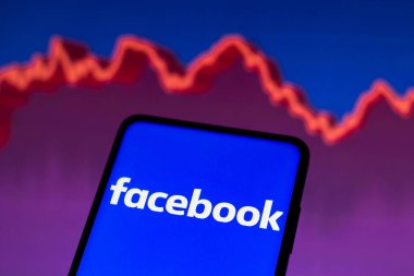 4 Mayıs 2022, Brezilya. Bu resimde Facebook logosu, arka planda borsanın grafik temsili ile akıllı telefon ekranında görüntülendi.