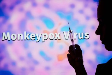 May 23, 2022, Brazil. In this photo illustration, a person holding a medical syringe with the word Monkeypox in the background. It is a viral disease that occurs mainly in central and western Africa. It's called monkeypox clipart