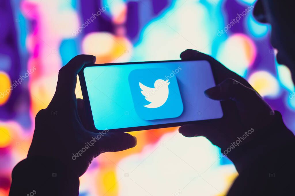 June 1, 2022, Brazil. In this photo illustration, a silhouetted woman holds a smartphone with the Twitter logo displayed on the screen