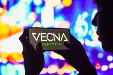 7 Haziran 2022, Brezilya. Bu resimde siluetli bir kadın ekranında Vecna Robotik logosu olan bir akıllı telefon tutuyor..