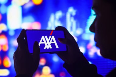 9 Haziran 2022, Brezilya. Bu resimde siluetli bir kadın ekranında AXA S.A. logosu olan bir akıllı telefon tutuyor.
