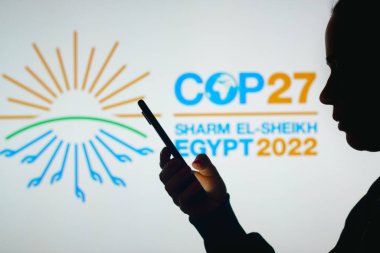 14 Haziran 2022, Brezilya. Bu resimde, bir kadının siluetinde 2022 Birleşmiş Milletler İklim Değişikliği Konferansı COP27 logosu yer alıyor.