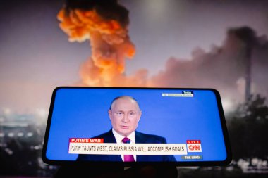 18 Haziran 2022, Brezilya. Bir kişi, Rusya Devlet Başkanı Vladimir Putin 'in canlı yayını ABD' den CNN TV kanalı üzerinden izliyor. Putin Batı 'yı kışkırttı ve Rusya' nın belirlenen hedefleri karşılayacağını söyledi