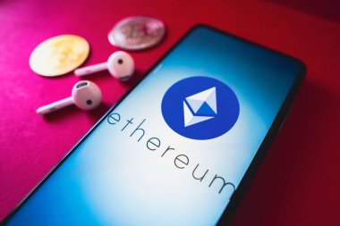 26 Haziran 2022, Brezilya. Bu resimde, Ethereum (ETH) logosu bir akıllı telefon ekranında, iki kripto para birimi ve kulaklığın yanında görüntülenir.