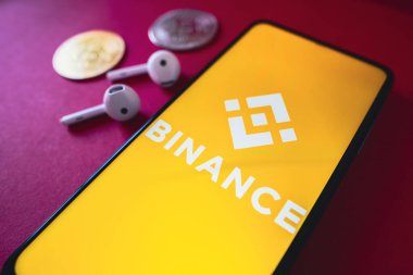 26 Haziran 2022, Brezilya. Bu resimde, Binance Coin (BNB) logosu akıllı telefon ekranında iki kripto para birimi ve kulaklığın yanında görüntülenir.