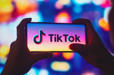 6 Temmuz 2022, Brezilya. Bu resimde siluetli bir kadın ekranda TikTok logosu olan bir akıllı telefon tutuyor.