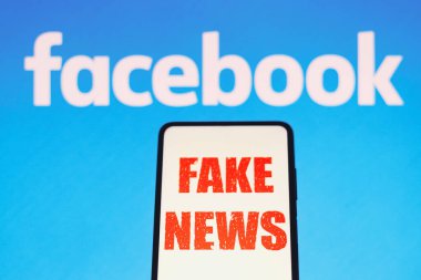 July 13, 2022, Brazil. In this photo illustration, the words 'fake news' are displayed on a smartphone with a Facebook logo in the background