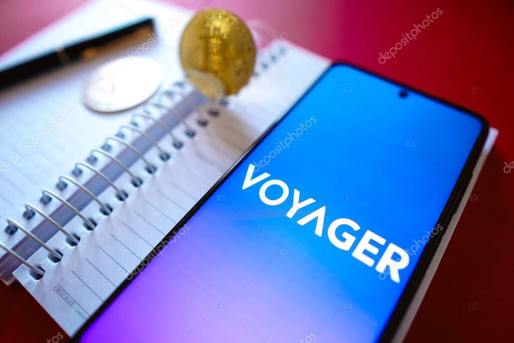July 19, 2022, Brazil. In this photo illustration the Voyager Digital logo seen displayed on a smartphone screen, on the side of Bitcoin cryptocurrencies